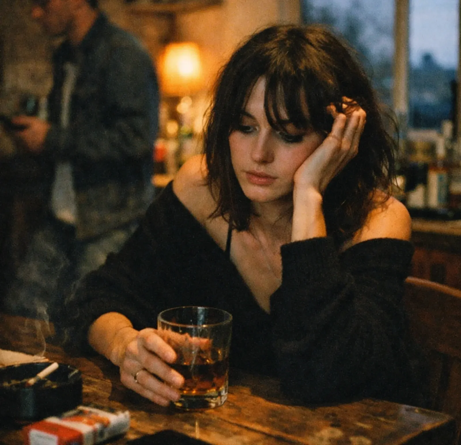 A woman contemplating a drink at a dimly lit bar