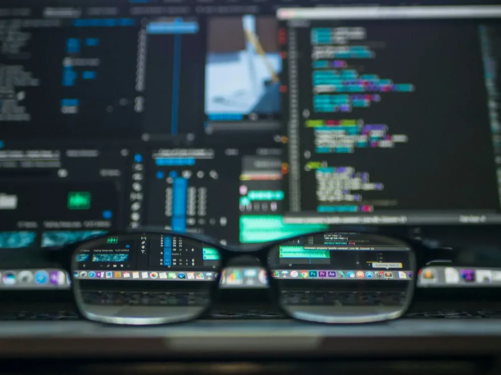 Glasses resting before screens of code